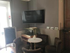 a living room with a table and a flat screen tv at Les 2 grives - auberge restaurant in Bras-dʼAsse