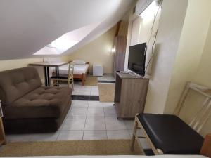 a living room with a couch and a television at Marex Centar in Jabuka