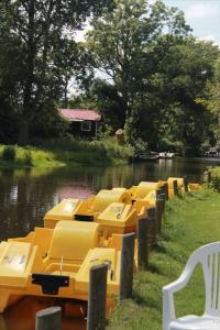 a row of yellow boats parked in the water at Riverside Voerså in Sæby