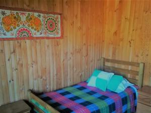 um quarto com uma cama numa parede de madeira em Hostal Casona del Cerro em Constitución