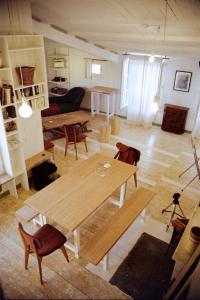 una gran sala de estar con mesa de madera y sillas. en Logement Design à Loix-en-Ré - 2 étoiles - Centre Village, en Loix
