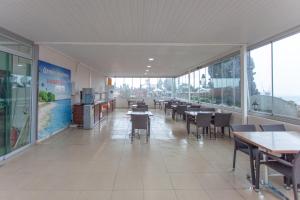 uma sala de jantar com mesas, cadeiras e janelas em Ozmen Hotel em Antalya