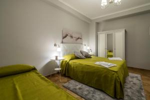 - une chambre avec un lit vert et une table dans l'établissement Domus Prati, à Rome