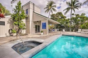 a swimming pool in front of a house at Top-Floor Kailua Bay Resort Condo with Ocean Views! in Kailua-Kona