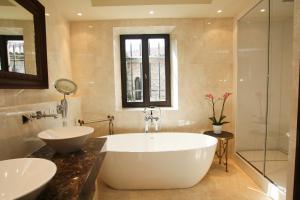 a bathroom with a large tub and two sinks at Chateau Eza in &Eacute;ze