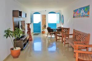 a living room with chairs and a table and windows at Pousada Rio do Prado in Porto Seguro