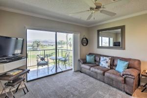 a living room with a couch and a tv and a balcony at Lake Havasu Getaway with Golf Course and Lake Views! in Lake Havasu City