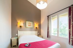 ein Schlafzimmer mit einem Bett mit einer rosa Decke und einem Fenster in der Unterkunft Village Pierre & Vacances Le Rouret in Grospierres