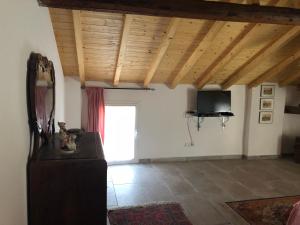 een woonkamer met houten plafonds en een televisie bij Ampio e luminoso appartamento a 2 passi da Pavia in Cava Manara