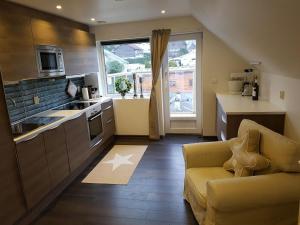 uma cozinha com um sofá e uma cozinha com uma janela em Lagunen Apartments em Bergen