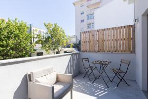 Un patio con sillas y una mesa en el balcón. en Porto Home by PCALE, en Oporto