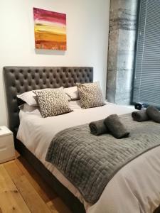 een slaapkamer met een groot bed met kussens erop bij Royal William Yard Apartment in Plymouth
