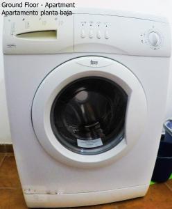 a white washing machine with its door open at Apartamentos Ester in Santa Cruz de Tenerife