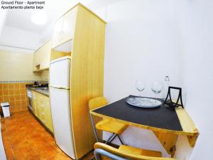 a kitchen with a table with two wine glasses on it at Apartamentos Ester in Santa Cruz de Tenerife