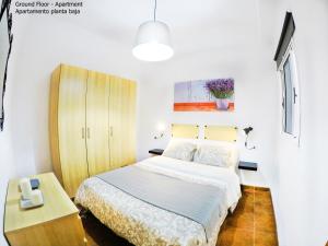 a bedroom with a bed and a wooden cabinet at Apartamentos Ester in Santa Cruz de Tenerife