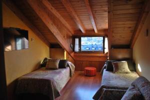 a attic room with two beds and a window at Las Maticas in Molinaseca