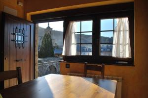 a dining room with a table and a large window at Las Maticas in Molinaseca