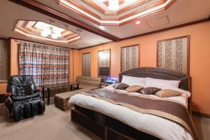una camera da letto con un letto grande e una sedia di ホテル ドルフィンリゾート 岐阜 -大人専用- a Gifu