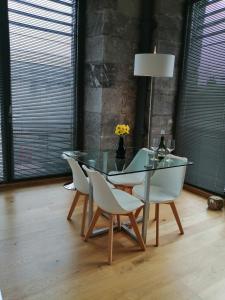 een glazen tafel en stoelen in een kamer met ramen bij Royal William Yard Apartment in Plymouth