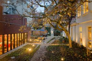 a backyard with a tree and a house at The Green Elephant Hostel & Spa in Maastricht