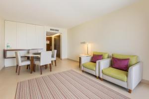 a living room with two chairs and a table at NAU Sao Rafael Suites - All Inclusive in Albufeira