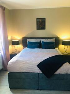 a bedroom with a large bed with blue pillows at Villa Rosa Bad Camberg in Bad Camberg