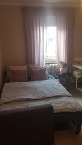 a large bed in a bedroom with a window at Villa Rosa Bad Camberg in Bad Camberg