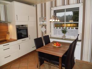 een keuken met een tafel en stoelen en een raam bij Ferienhaus Heideblüte in Schneverdingen