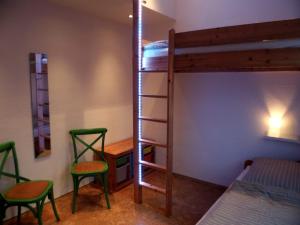 Zimmer mit 2 Stühlen und einem Etagenbett in der Unterkunft Ferienhaus Heideblüte in Schneverdingen