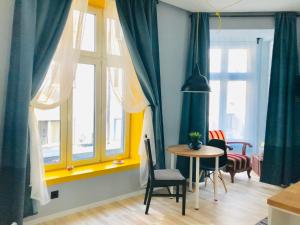 Una habitación con una mesa y sillas y ventanas. en Courthouse Apartments Slavi, en Sofía
