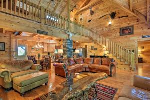 a living room with leather furniture and a staircase at Trenton Cabin with Hot Tub - 14 Mi to Lookout Mtn! in Trenton