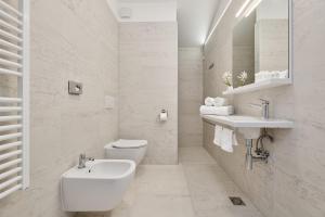 a white bathroom with a sink and a toilet at B&B Artegnana 1798 in Grožnjan