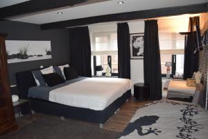 Un dormitorio con una cama grande y una ventana en Studio frodo en zazou, en Maaseik