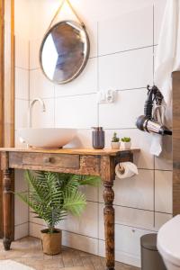 ein Bad mit einem Waschbecken und einem Spiegel in der Unterkunft Pod Mazurskim Niebem boho in Piecki