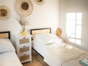 a bedroom with two twin beds and a nightstand at Pod Mazurskim Niebem boho in Piecki