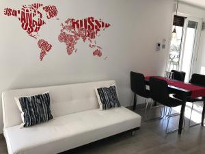 ein Wohnzimmer mit einer weißen Couch und einer Weltkarte an der Wand in der Unterkunft EXCLUSIVO TAPAS EL TUBO CHECKIN 24H Centro 1 in Saragossa + 34 Fotos