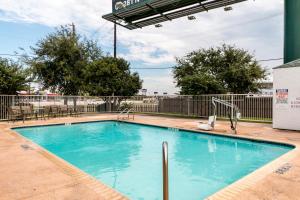 a swimming pool with blue water in front of a fence at Motel 6-San Antonio, TX - South in San Antonio