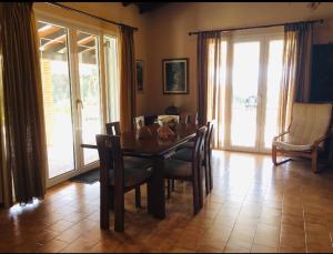 a dining room with a wooden table and chairs at Casa Del Mare (South Evia) in Nea Stira