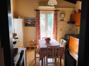 a kitchen with a table with chairs and a window at Casa Del Mare (South Evia) in Nea Stira +13 photos