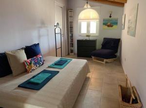a living room with a large bed and a chair at Casa Del Mare (South Evia) in Nea Stira