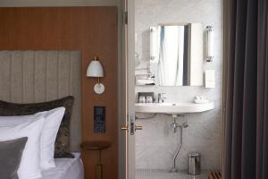 a bedroom with a sink and a mirror on the wall at Original Sokos Hotel Vaakuna Helsinki in Helsinki