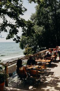 een groep mensen die aan tafels bij de oceaan zitten bij Drake Devonshire and Motor Inn in Wellington