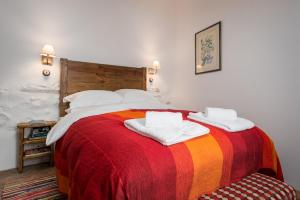a bedroom with a large bed with a colorful blanket at Casa Higueras in Moclín