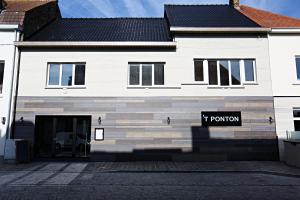 un edificio bianco con un cartello di una t di stanza di fronte di ‘t Ponton a Nieuwpoort