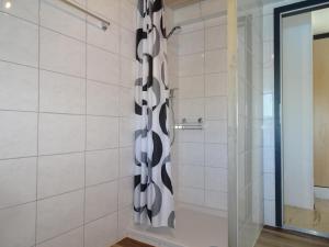 a shower with a black and white shower curtain at Fab Studio in Granges
