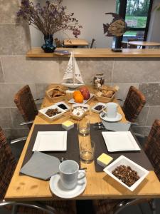 a wooden table with food and drinks on it at L’île aux Bateaux in Buzet-sur-Baïse