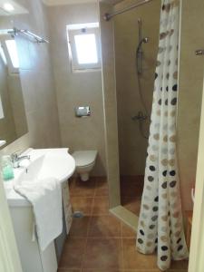 y baño con lavabo y ducha. en Villa Dianthe, en Myrtos