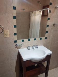 y baño con lavabo blanco y espejo. en Casa Cerro de la Luna en Salta