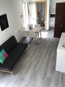 ein Wohnzimmer mit einem Sofa und einem Tisch in der Unterkunft MODERNO NUEVO Luminoso WI-FI PLAZA DEL PILAR 2 in Saragossa