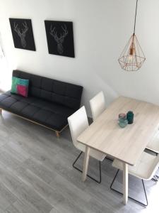 a living room with a black couch and a table at MODERNO NUEVO Luminoso WI-FI PLAZA DEL PILAR 2 in Zaragoza